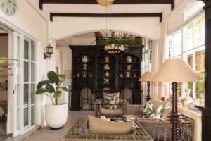 Cozy sitting area with dark wood shelving and rattan chairs at Villa Hingga