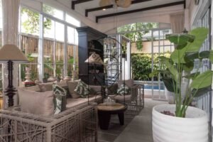 Cozy sitting area with dark wood shelving and rattan chairs at Villa Hingga