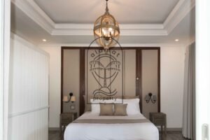 Bedroom with pool view through open glass doors at Villa Hingga
