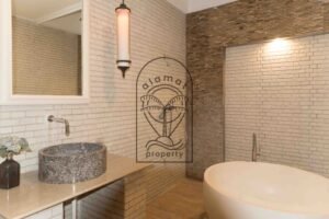 Bathroom with freestanding tub and stone-tiled walls at Villa Hingga