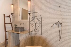 Bathroom with freestanding tub and stone-tiled walls at Villa Hingga