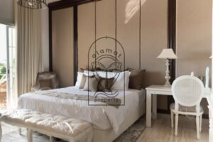 Bedroom with white cane wardrobe and TV unit at Villa Hingga