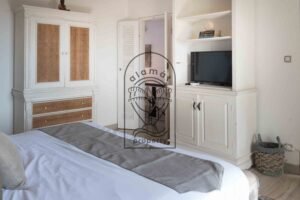 Bedroom with white cane wardrobe and TV unit at Villa Hingga