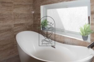 Bathroom with freestanding tub and stone-tiled walls at Villa Hingga