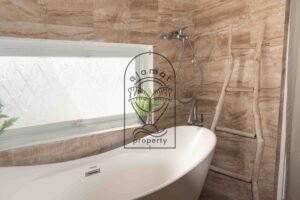 Bathroom with freestanding tub and stone-tiled walls at Villa Hingga