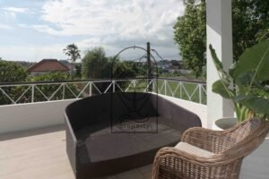 Covered terrace with rattan armchairs opening onto a bedroom at Villa Hingga