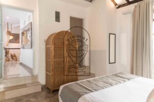 Bedroom with woven rattan wardrobe and hallway view at Villa Hingga