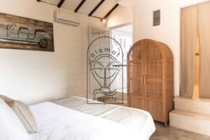 Bedroom with woven rattan wardrobe and hallway view at Villa Hingga