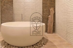 Bathroom with freestanding tub and stone-tiled walls at Villa Hingga