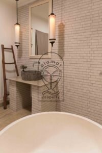 Bathroom with freestanding tub and stone-tiled walls at Villa Hingga