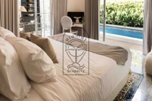 Bedroom with pool view through open glass doors at Villa Hingga