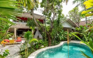 Villa Kaleidoscope exterior with curved swimming pool and tropical garden, Seminyak