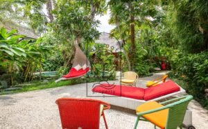 Villa Kaleidoscope garden pathway with hanging daybed and colorful chairs, Seminyak