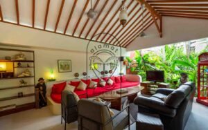 Villa Kaleidoscope living room with red sofa and vintage telephone booth, Seminyak