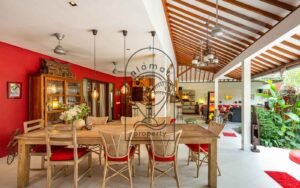 Villa Kaleidoscope dining room with red accent wall and wooden table, Seminyak