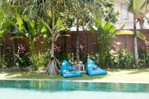 Villa Pachy blue bean bags under palm trees beside the pool