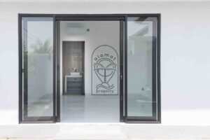 Bright white bedroom with ensuite bathroom in Villa Fenja