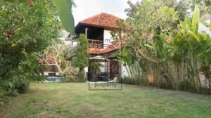 Two-story villa exterior surrounded by tropical garden at Villa Bugenvil