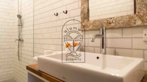 Bathroom with subway tile and marble-framed mirror at Villa Bugenvil