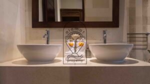 Bathroom with double vessel sinks and welcome towels at Villa Bugenvil