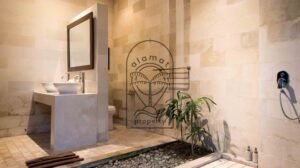 Open-air bathroom with stone walls and garden planting at Villa Bugenvil