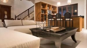 Living room with staircase and wooden bar seating at Villa Bugenvil