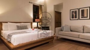 Bedroom with upholstered daybed and framed wall art at Villa Bugenvil