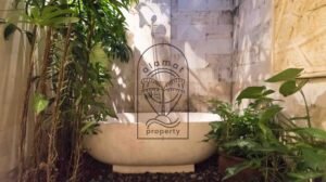 Freestanding bathtub surrounded by tropical plants at Villa Bugenvil