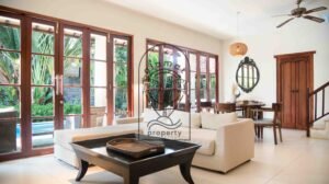 Living room with french doors opening to the pool at Villa Bugenvil