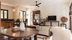 Open-plan living and dining area with carved wood mirror at Villa Bugenvil