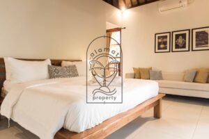 Bedroom with beige sofa and framed wall art at Villa Bugenvil