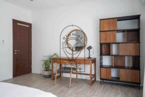 Bedroom desk with round mirror and wood shelving unit at Villa Aruna Sari