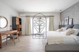 Bedroom with green accent wall and rattan nightstands at Villa Aruna Sari
