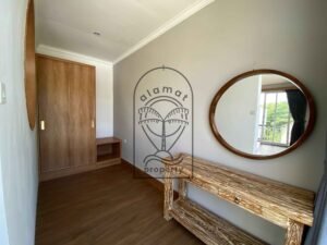 Bright bedroom with round mirror and rustic wood bed at Villa Ramaia