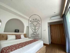 Bright bedroom with rustic wood bed at Villa Ramaia