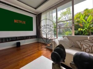 Home cinema lounge with projector screen and cozy sofas at Villa Kemuning