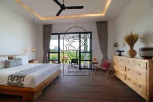Villa Melati bedroom with wooden dresser and glass terrace doors, Berawa Bali