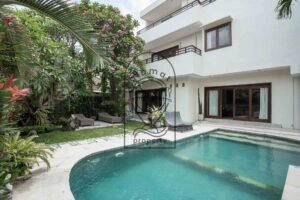 Villa exterior with pool, garden, and frangipani tree at Villa Aruna Sari