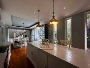Open kitchen with stone island bench and dining area at Villa Kemuning