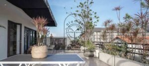 Rooftop terrace with outdoor dining table and city view at Villa Aruna Sari