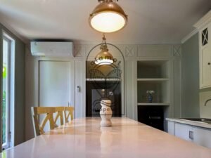 Open kitchen with stone island bench and dining area at Villa Kemuning