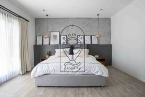 Bedroom with dark headboard and framed wall art at Villa Aruna Sari