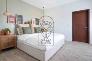 Bedroom with sage green wall and botanical wall art at Villa Aruna Sari