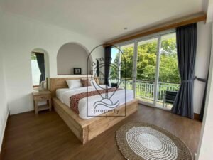 Bright bedroom with rustic wood bed at Villa Ramaia
