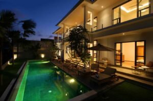 Villa Melati exterior at night with illuminated pool and open bedroom, Berawa Bali