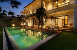 Villa Melati exterior at night with pool and lounge chairs, Berawa Bali