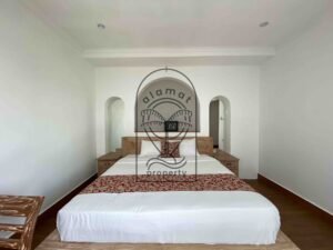 Bright bedroom with rustic wood bed at Villa Ramaia