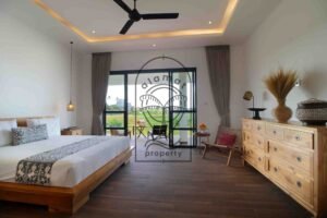 Villa Melati bedroom with wood dresser and ricefield terrace view, Berawa Bali