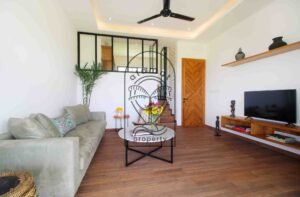 Villa Melati living room with grey sofa and mezzanine window, Berawa Bali