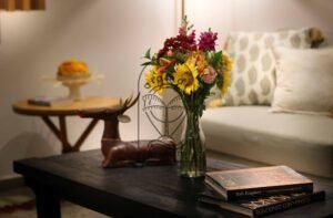 Villa Melati coffee table detail with sunflowers and wooden deer sculpture, Berawa Bali